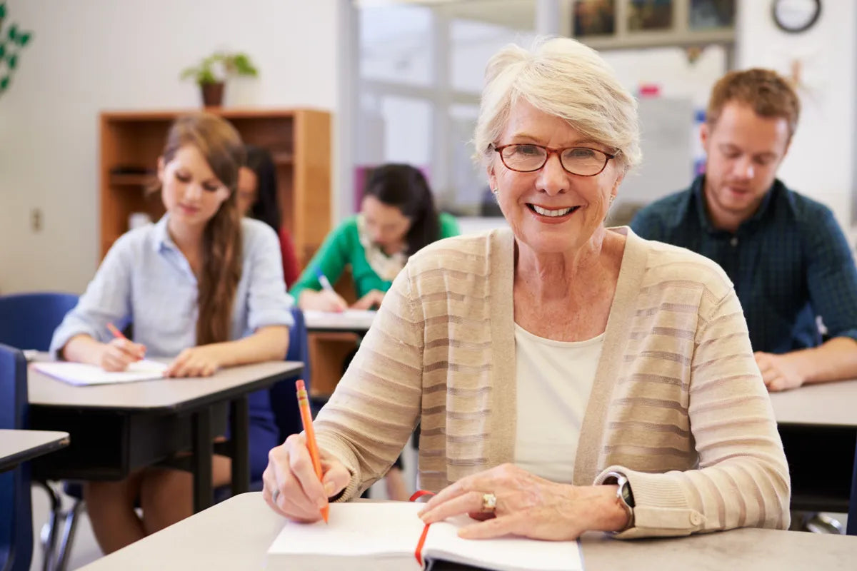 An older adult Spanish student smiling in a classroom