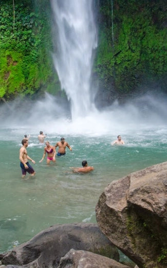 Visitors swimming below La Fortuna Waterfall in Costa Rica